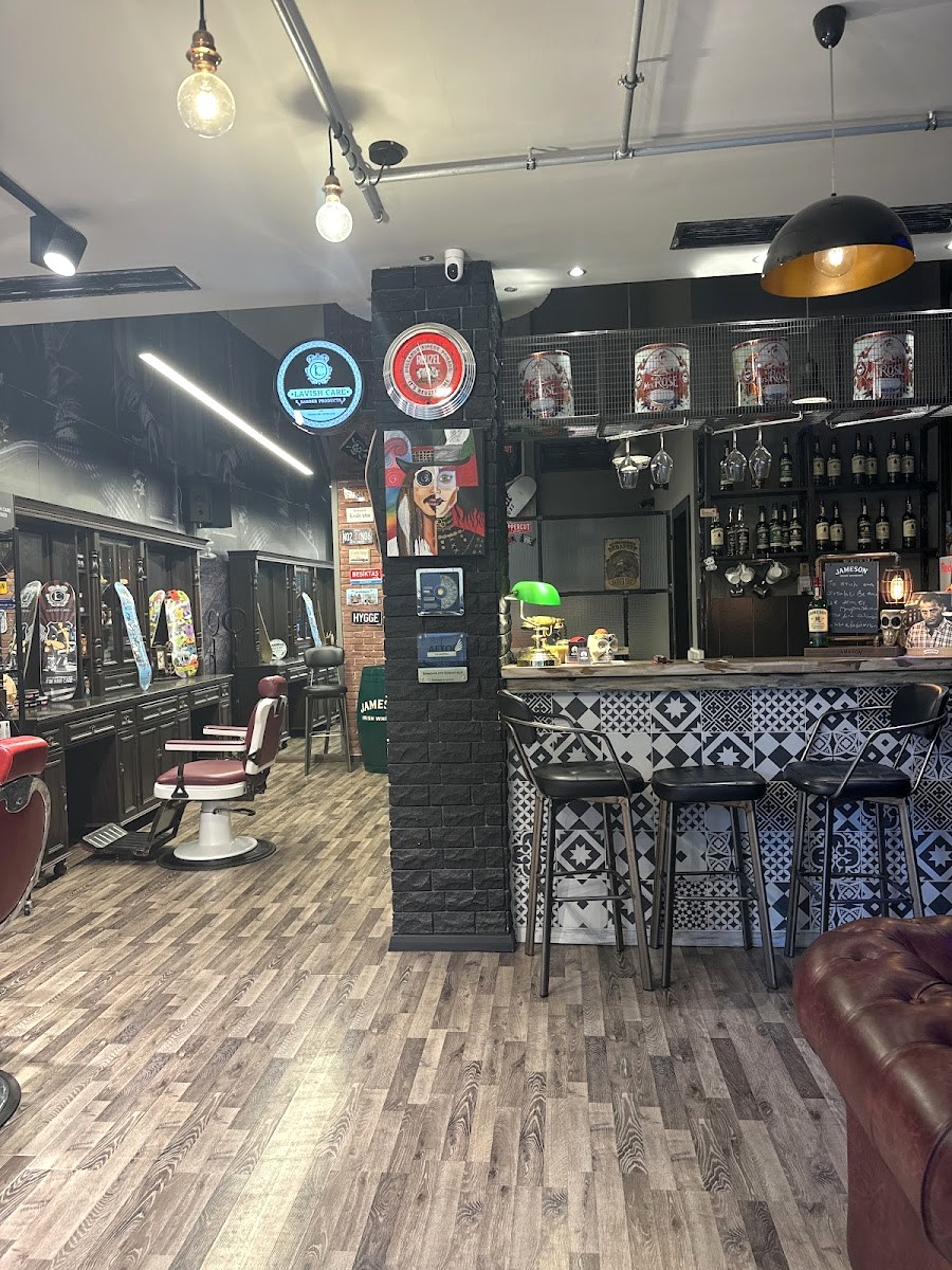 Το μπαρ μέσα στο κουρείο Barberians: ξύλινος πάγκος, Jameson, φωτιστικά Edison και η τοιχογραφία του βασιλιά στην Καμάρα