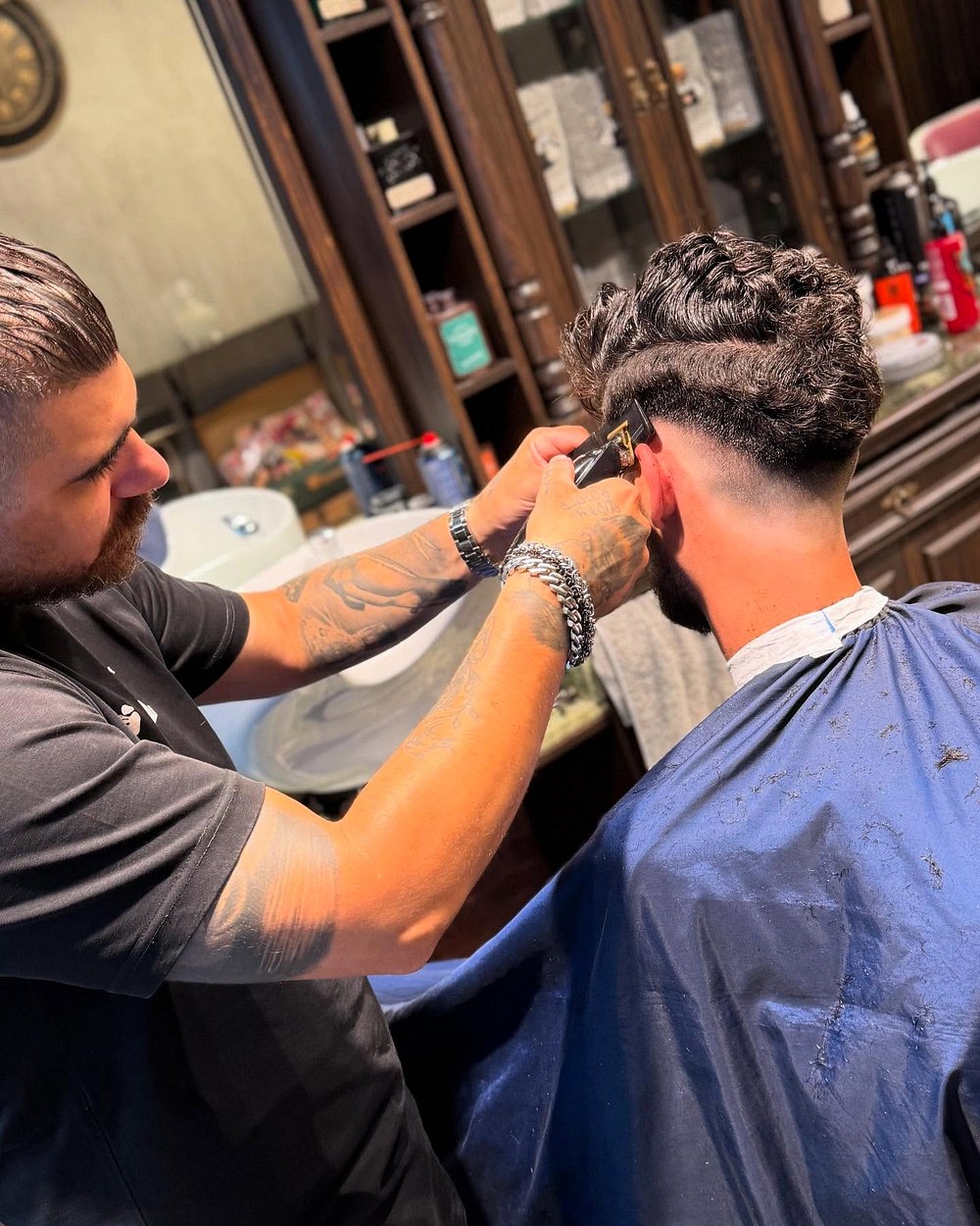 Barber του Barberians εν ώρα δράσης, κουρεύει πελάτη στην καρέκλα